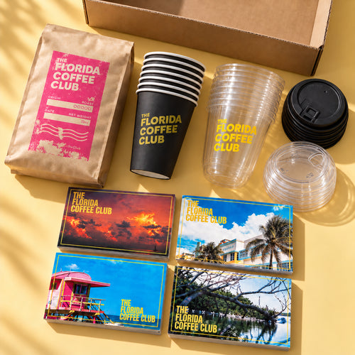 The Florida Coffee Club Host Kit flat lay with coffee bag, hot and cold cups, lids and postcards
